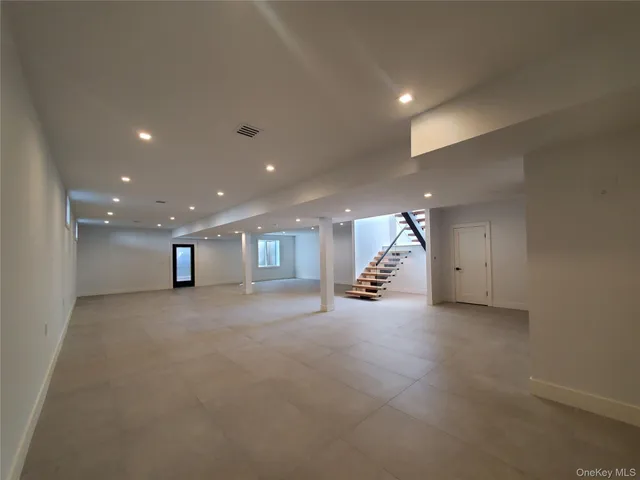 an empty room with windows and fireplace