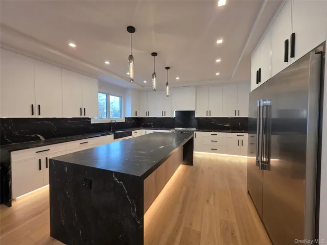 a kitchen with kitchen island a sink appliances and cabinets