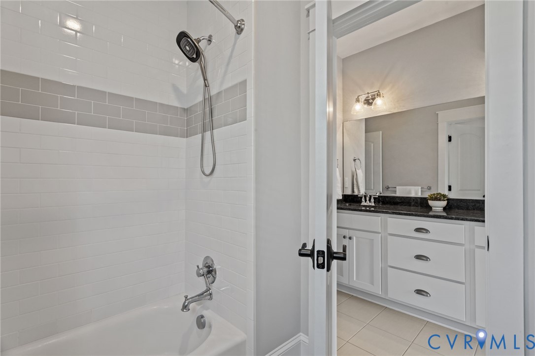 2313 Cheverton Lane Midlothian, VA 23112 - Photo 43 of 62 a bathroom with a granite countertop sink a mirror and a bathtub