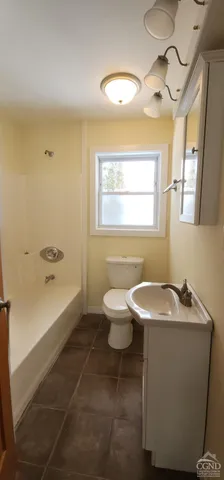 a white toilet sitting next to a bath tub