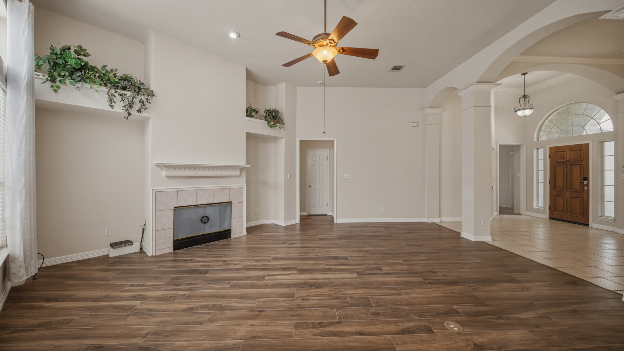 1108 Antelope Ridge Cedar Park, TX 78613 - Photo 4 of 27 Natural light illuminates rich wood flooring, complementing a cozy fireplace in this generously sized room.