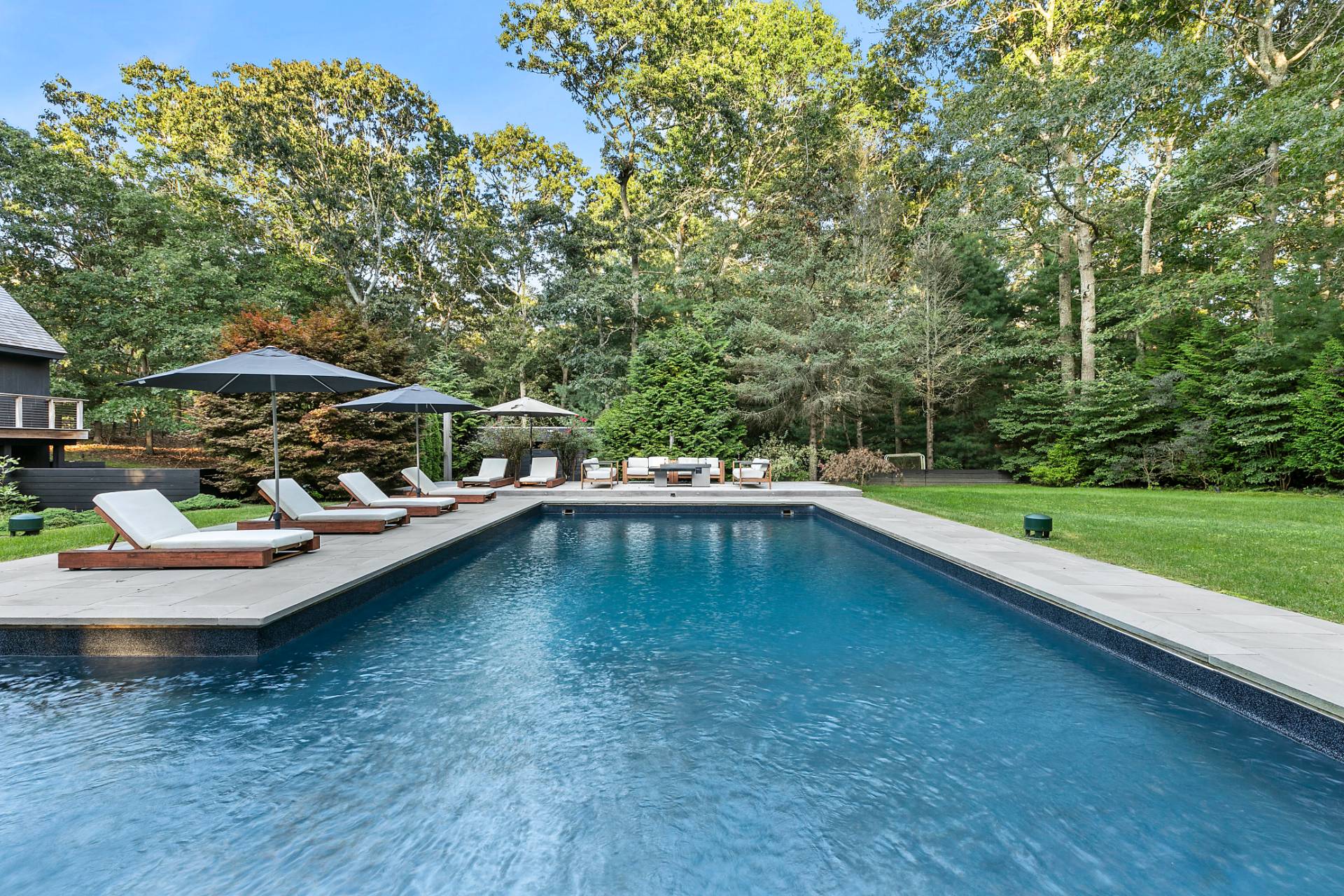 5 Jasons Lane East Hampton, NY 11937 - Photo 11 of 12 a view of swimming pool with lawn chairs under an umbrella