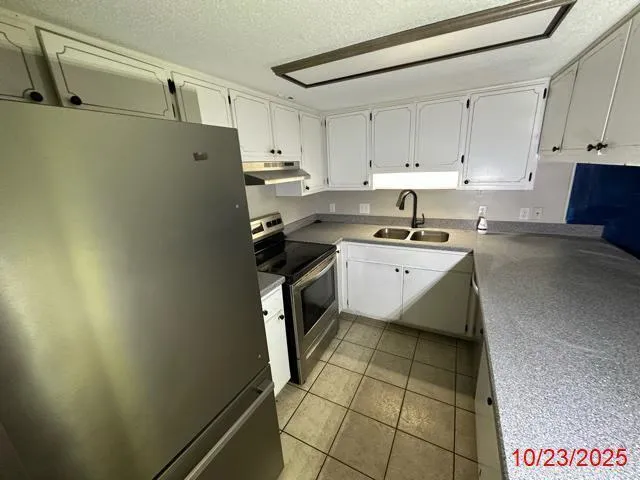 a kitchen with a sink a stove and cabinets