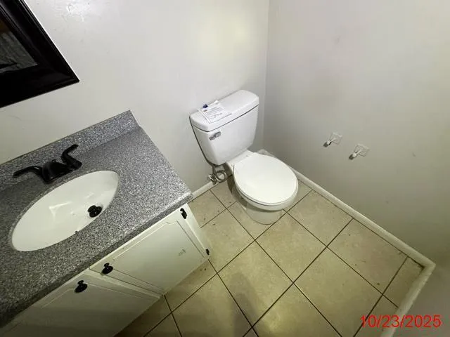 a bathroom with a granite countertop sink and a toilet