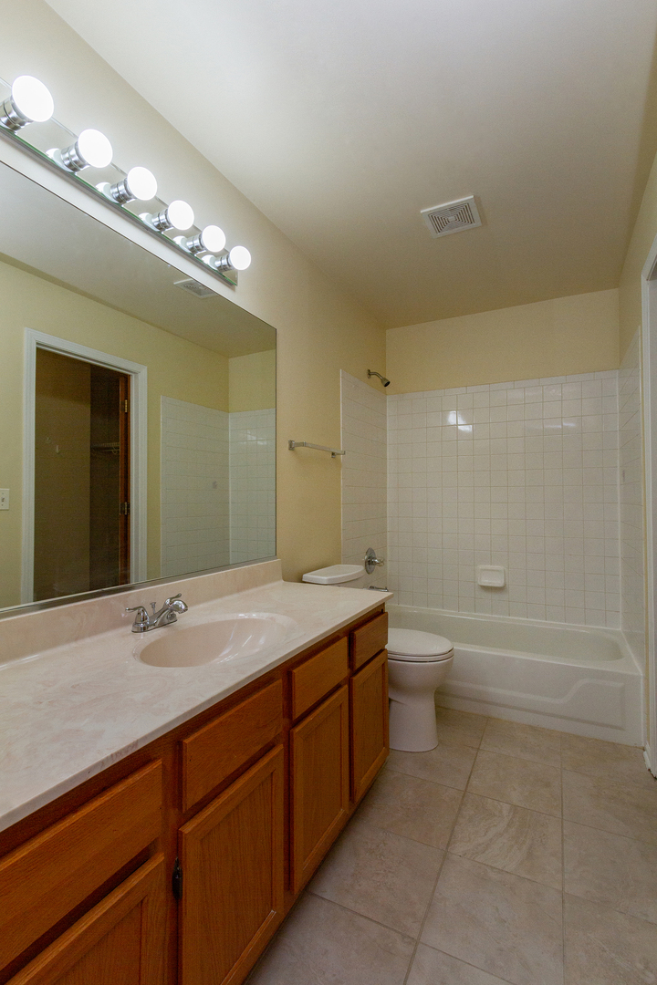 2624 Idaho Road Naperville, IL 60564 - Photo 17 of 23 a spacious bathroom with a granite countertop sink a toilet mirror and bathtub