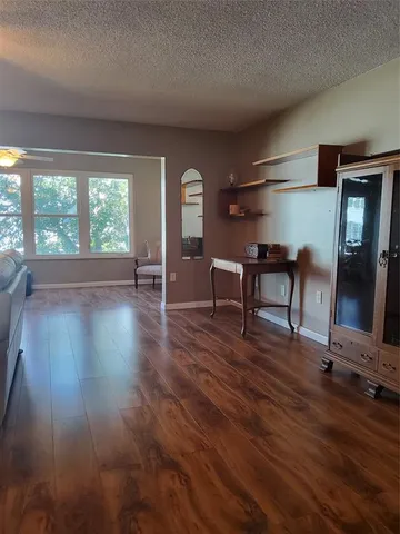 a view of a livingroom with furniture wooden floor and a window