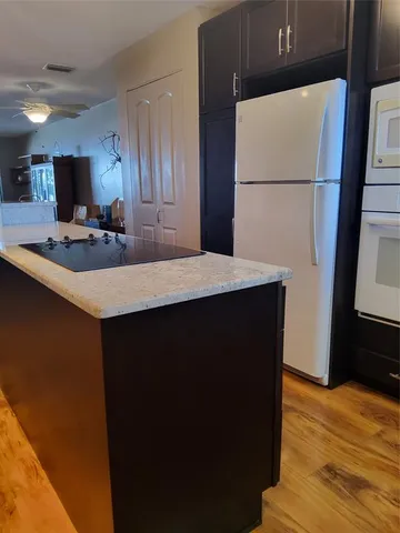 a kitchen with a sink a refrigerator and a stove top oven