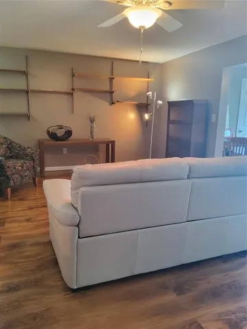 a living room with furniture and a ceiling fan