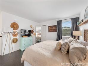 4590 Southwest 68th Ct Circle, Unit 8 Miami, FL 33155 - Photo 9 of 11 a bedroom with a bed a mirror and a window