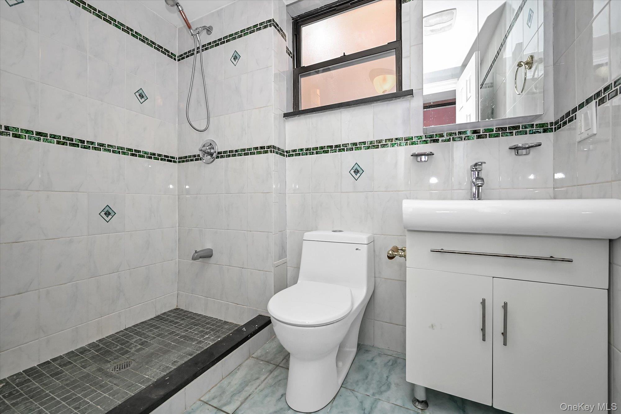 53-08 193rd Street Queens, NY 11365 - Photo 12 of 17 a bathroom with a toilet a sink and a shower