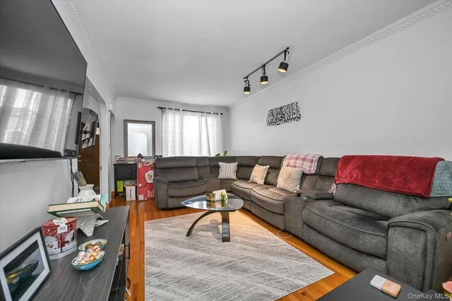 a living room with furniture and a dining table with wooden floor