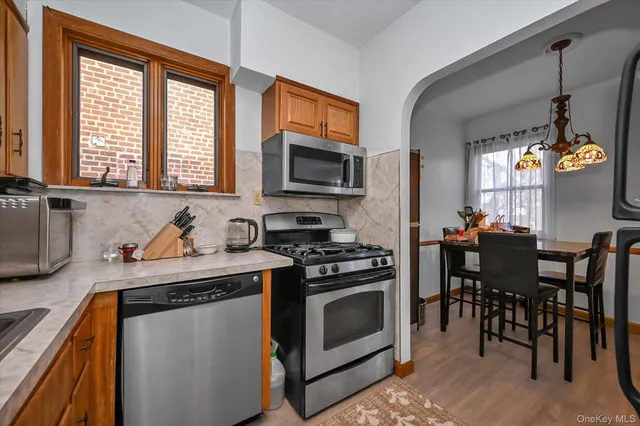 a kitchen with stainless steel appliances granite countertop a stove a sink and a microwave