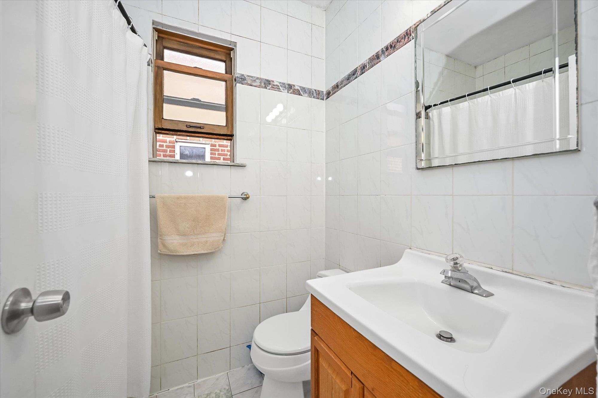53-08 193rd Street Queens, NY 11365 - Photo 9 of 17 a bathroom with a sink toilet and vanity