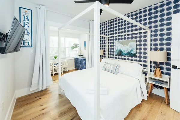 a large bedroom with a bed and wooden floor