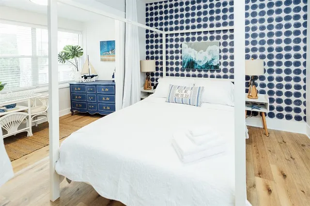 a large bed sitting in a bedroom next to a window with pc on the wall