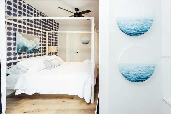 a view of a bedroom with a bed and wooden floor