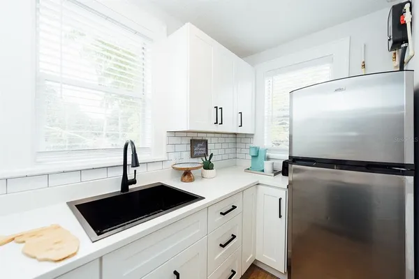 a close view of a sink and dishwasher with wooden floor