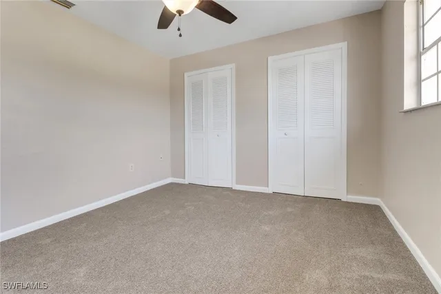 an empty room with chandelier fan