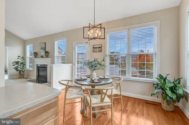 a kitchen with stainless steel appliances kitchen island granite countertop a table chairs and a stove