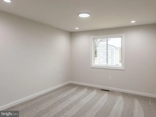 an empty room with a bathroom and a window