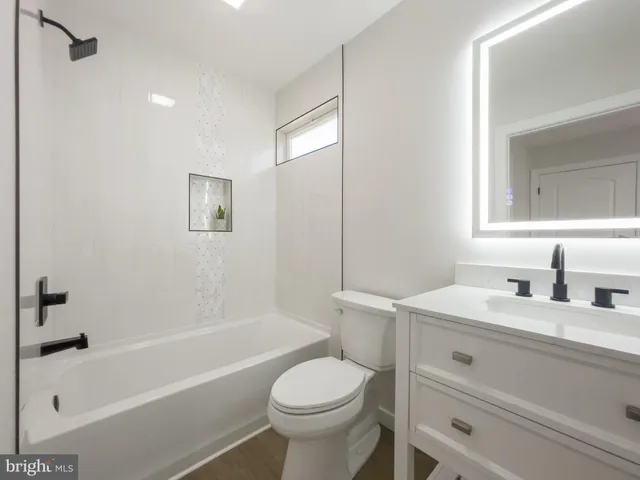 a bathroom with a sink toilet vanity and bathtub