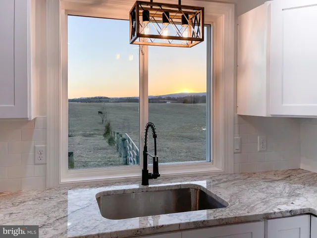 a kitchen with granite countertop white cabinets and a stove