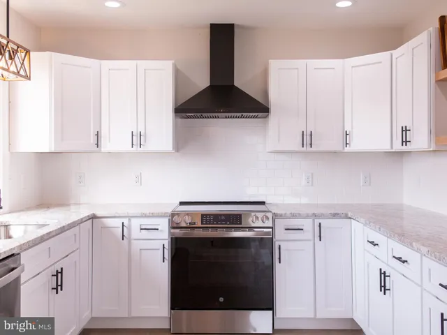 an empty room with wooden floor chandelier fan and windows