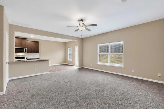 a view of a livingroom with a kitchen stove cabinets and a kitchen
