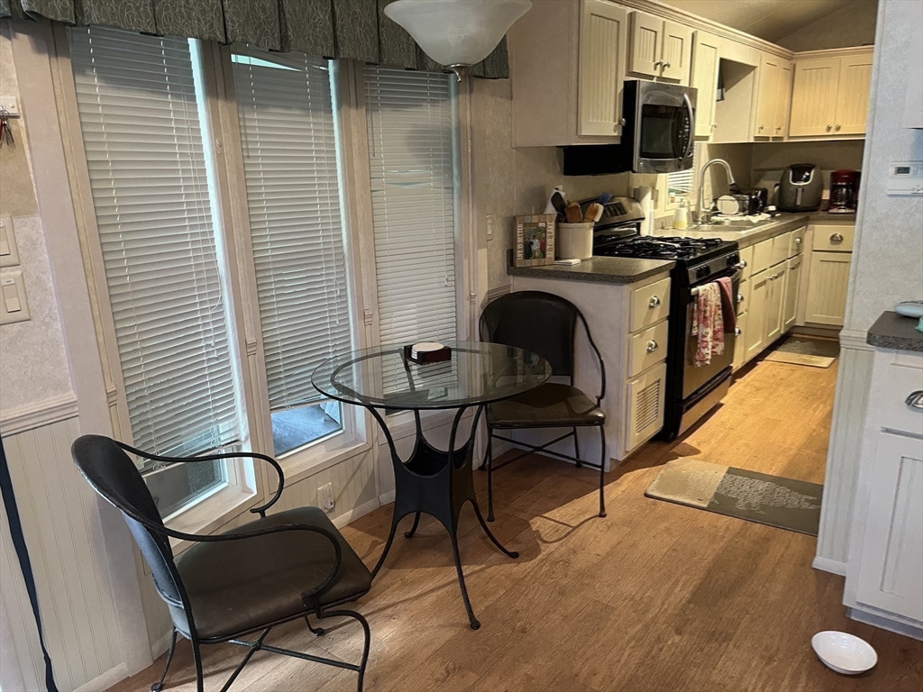 262 Shetucket Turnpike, Unit 112 Griswold, CT 06351 - Photo 5 of 25 a kitchen with stainless steel appliances kitchen island granite countertop dining room cabinets and granite counter tops