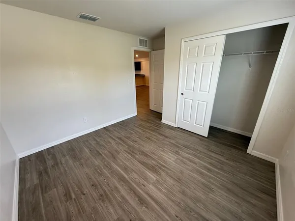 an empty room with wooden floor and closet