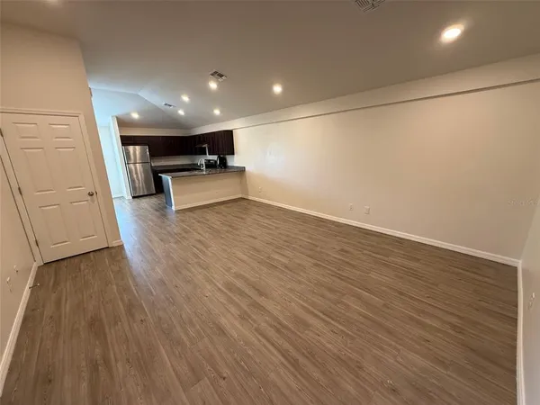 a view of empty room with wooden floor
