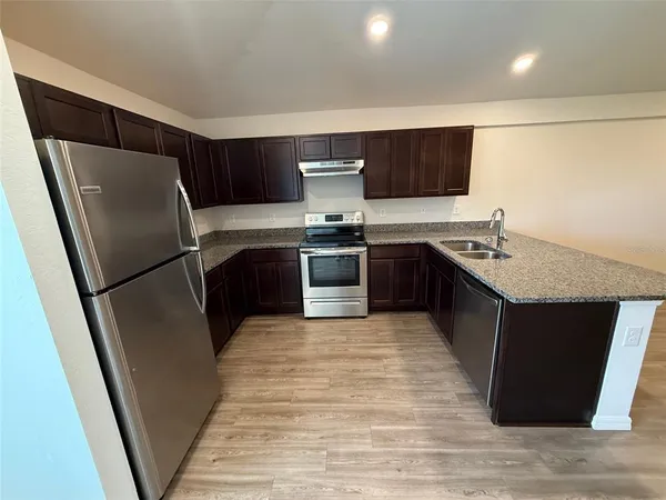 a kitchen with stainless steel appliances granite countertop a sink stove and refrigerator