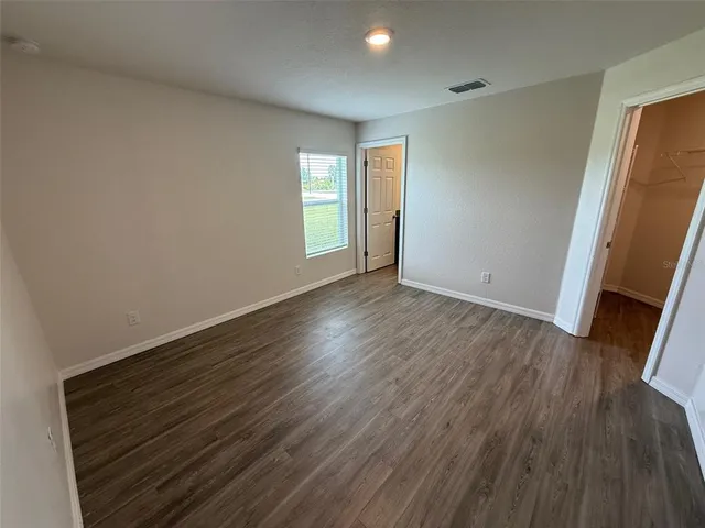 an empty room with wooden floor and window
