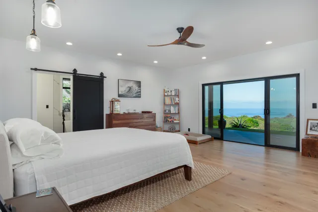 a spacious bedroom with a bed and a dresser