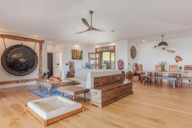 a living room with furniture a clock and a large window