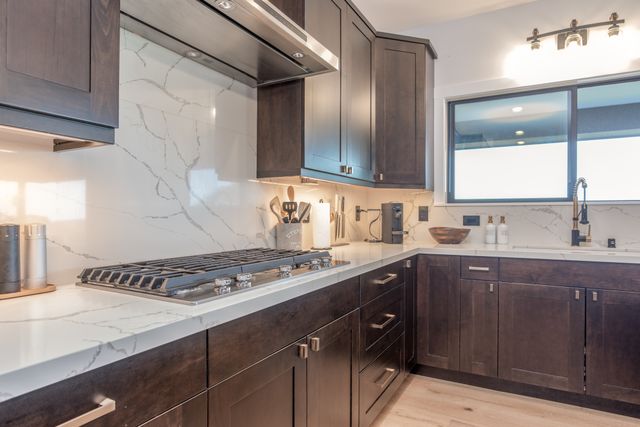 a kitchen with a sink a stove and cabinets