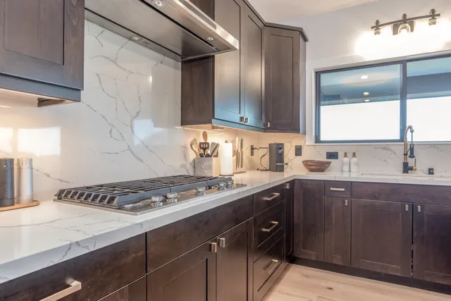 a kitchen with a sink a stove and cabinets