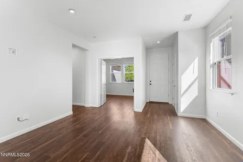 a view of a livingroom with wooden floor and a ceiling fan