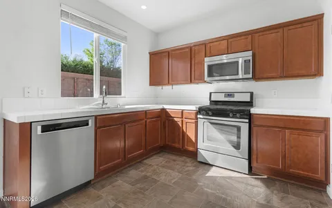 a kitchen with stainless steel appliances granite countertop a stove microwave and refrigerator