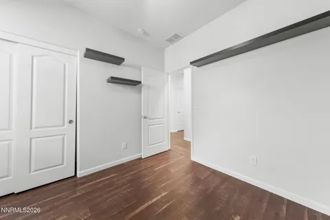 a view of a hallway with a window and a chandelier fan