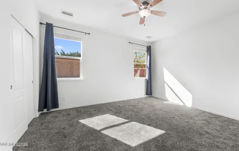an empty room with a ceiling fan and window