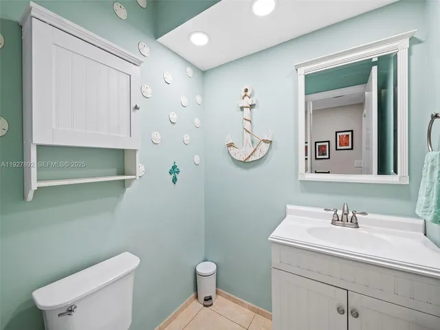 a bathroom with a toilet sink vanity and mirror