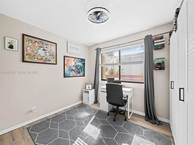 a view of a workspace with furniture and a window