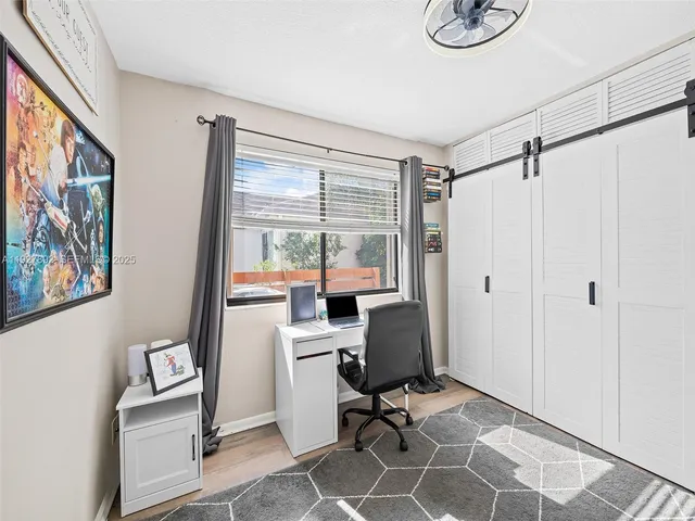a view of a workspace with furniture and a window
