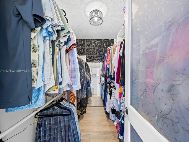 a view of walk in closet with clothes