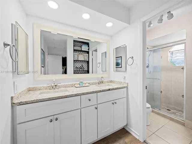 a bathroom with a granite countertop sink mirror and shower