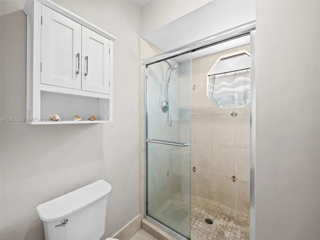 a bathroom with a shower a toilet and a sink