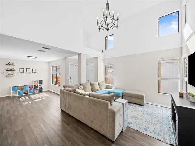 a living room with furniture and a chandelier