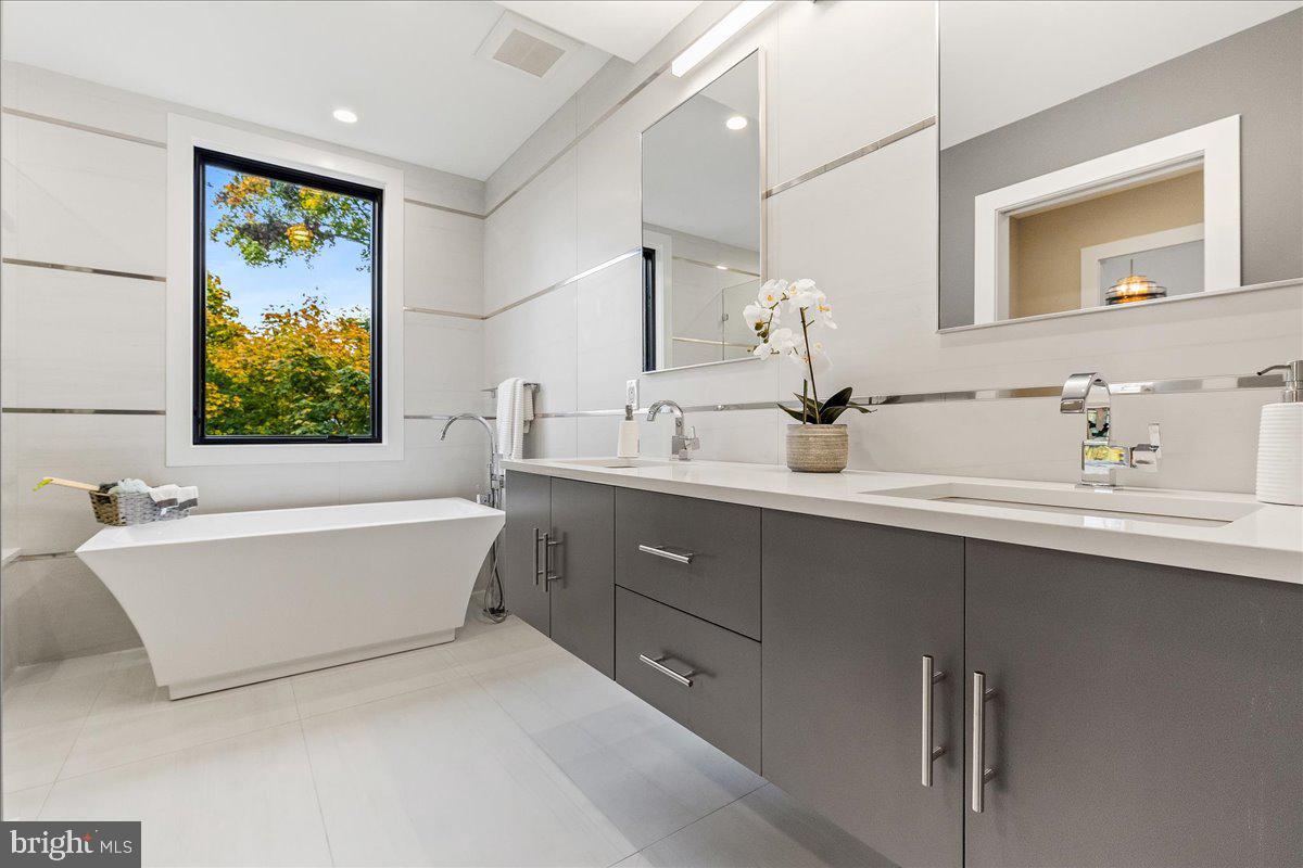 71 Maple Street Princeton, NJ 08542 - Photo 26 of 68 a bathroom with a double vanity sink a bathtub and mirror