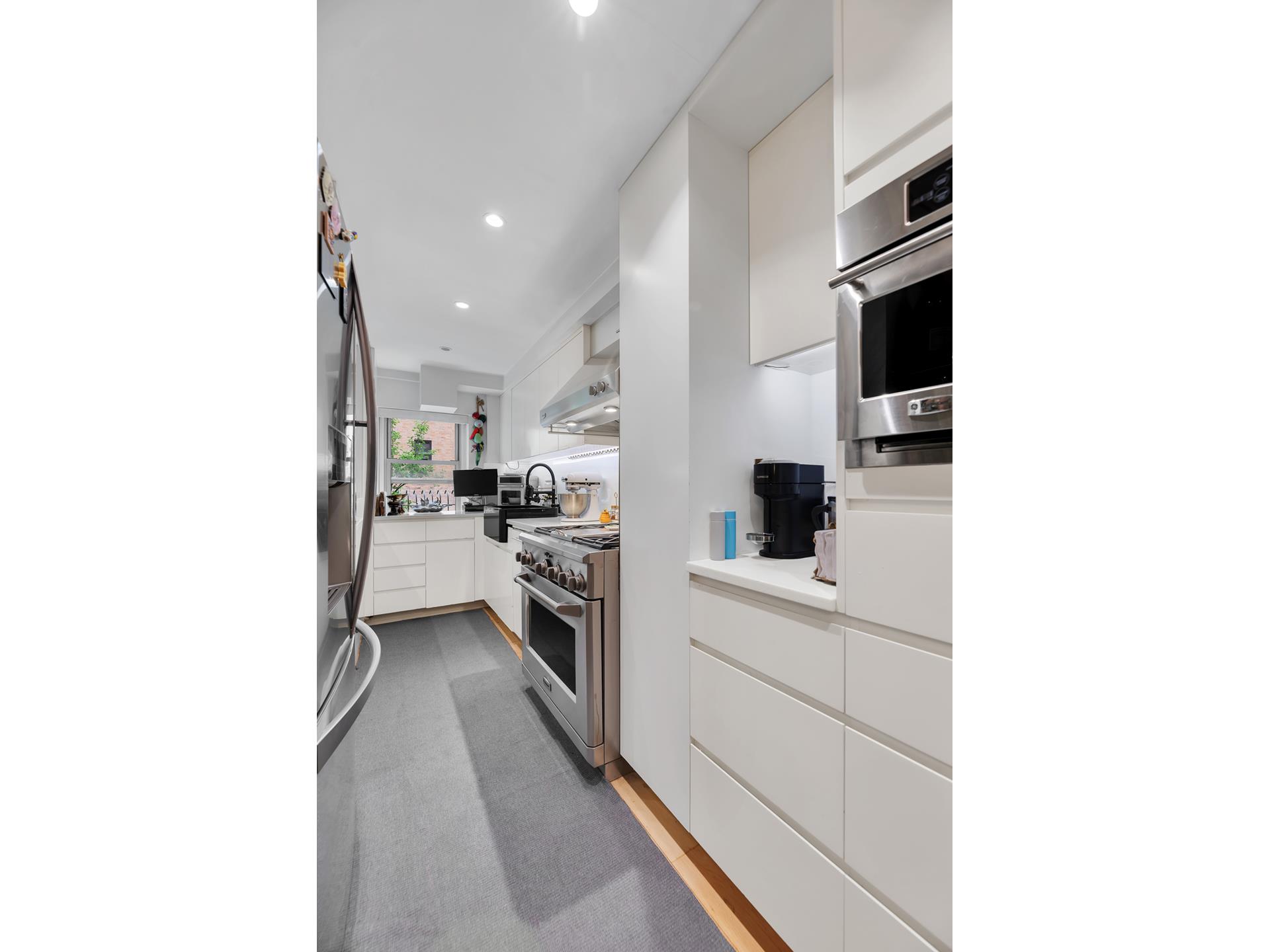 420 East 55th Street, Unit 3FG Manhattan, NY 10022 - Photo 6 of 8 a kitchen with stainless steel appliances kitchen island sink refrigerator and stove